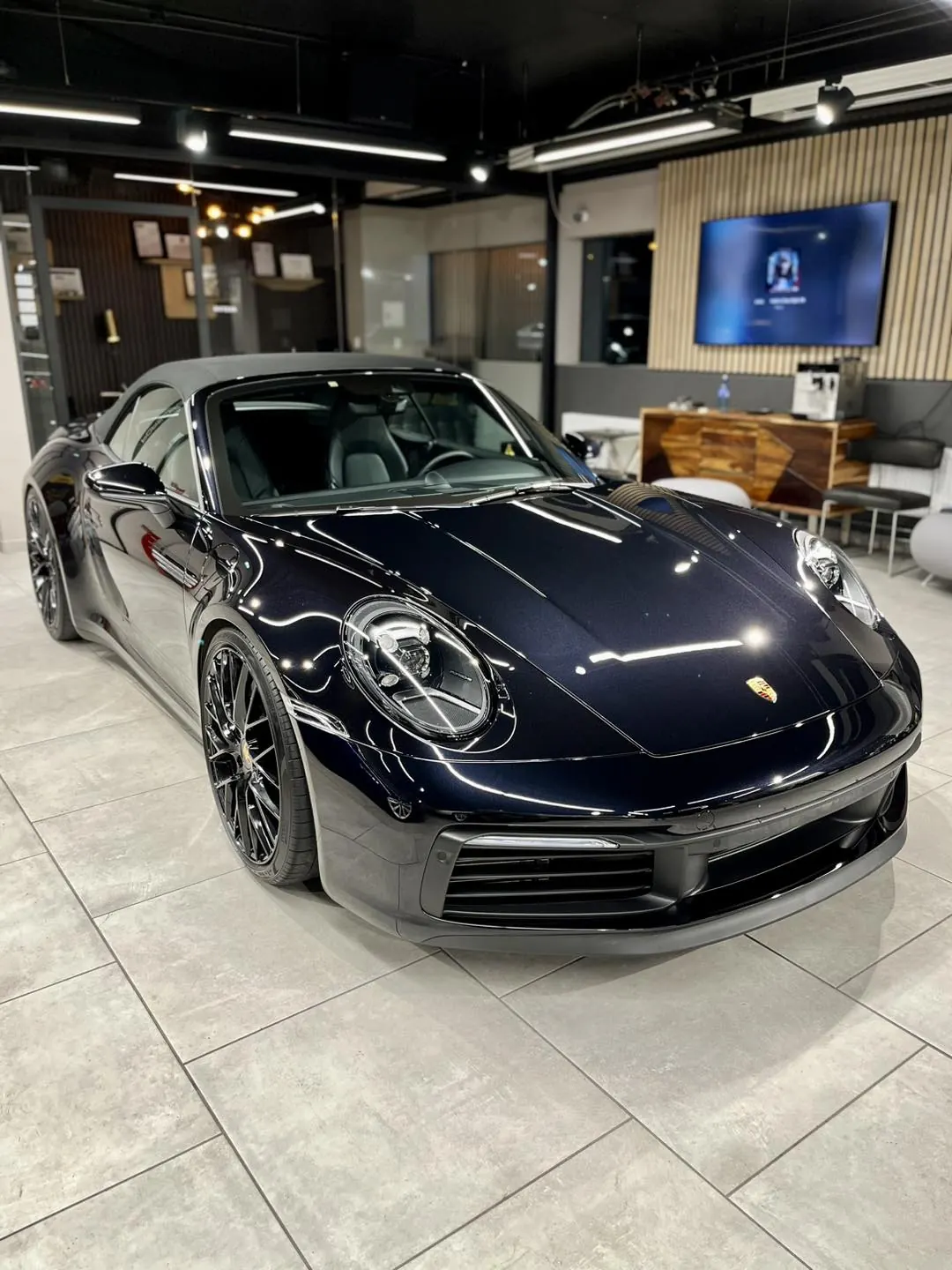 Mørkeblå Porsche 911 (992) innendørs
